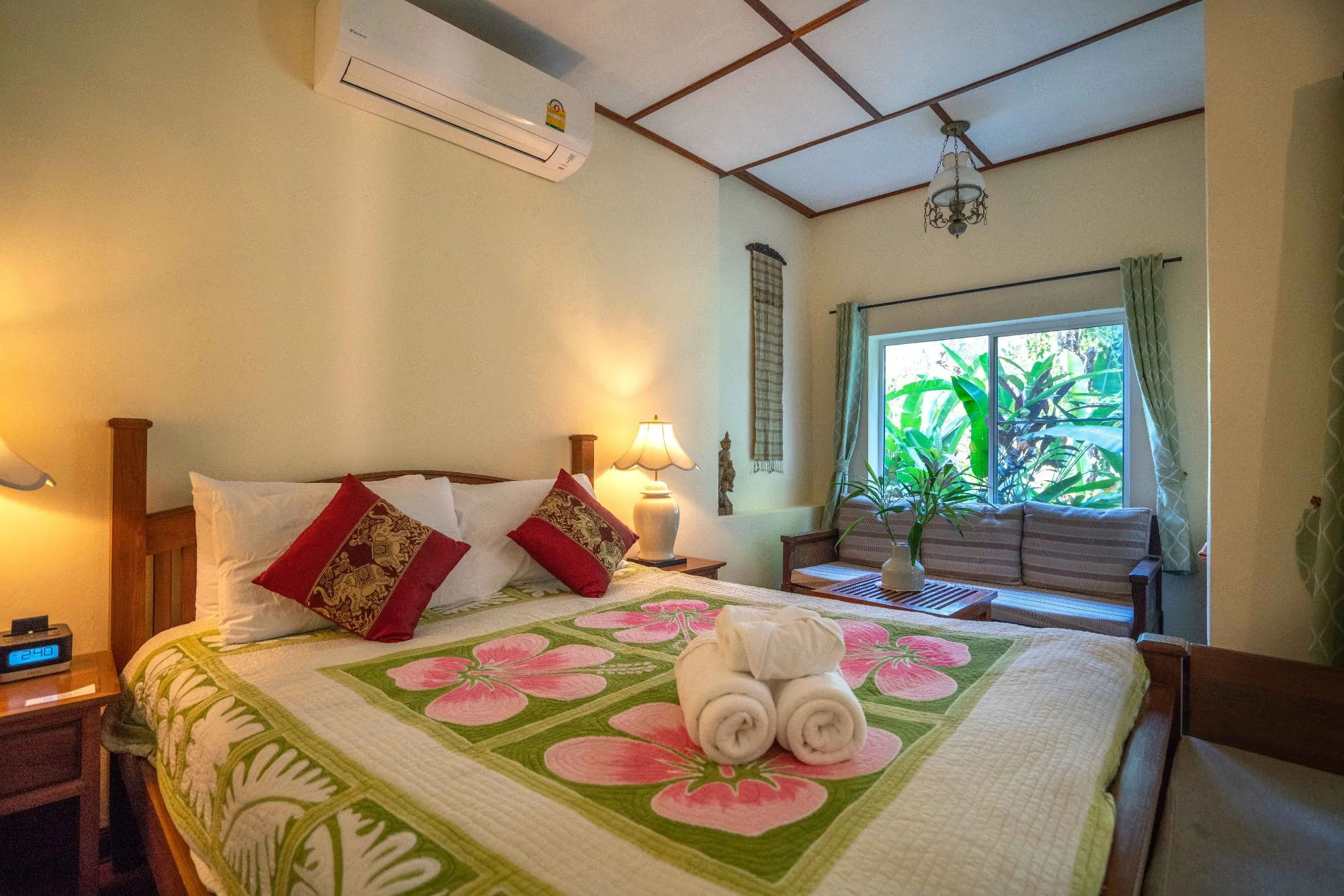 Air Nest bed with red cushions beneath a garden window