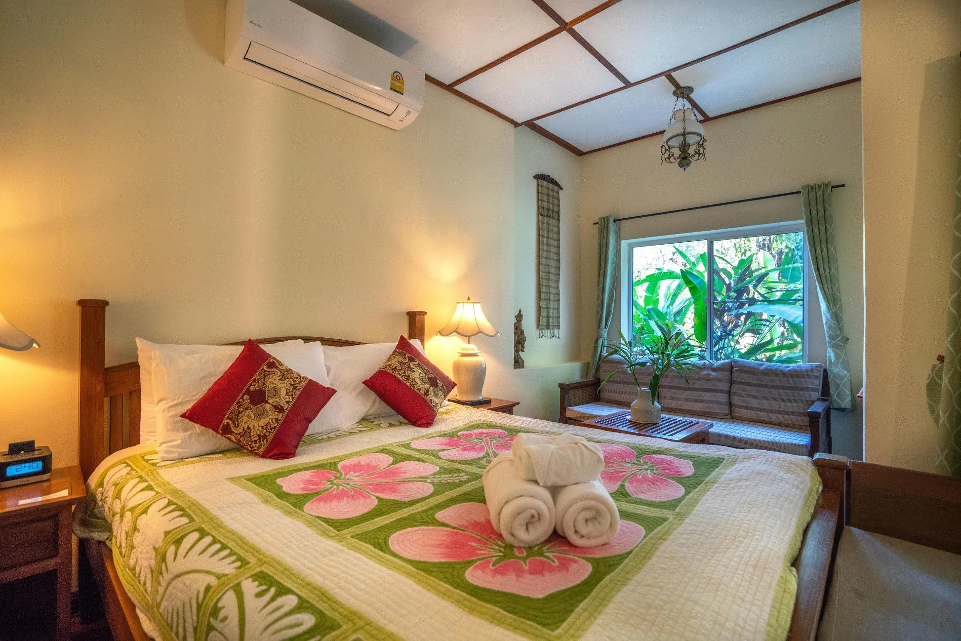 Deluxe room with rolled towels on a floral bedspread at Aerie Lodge