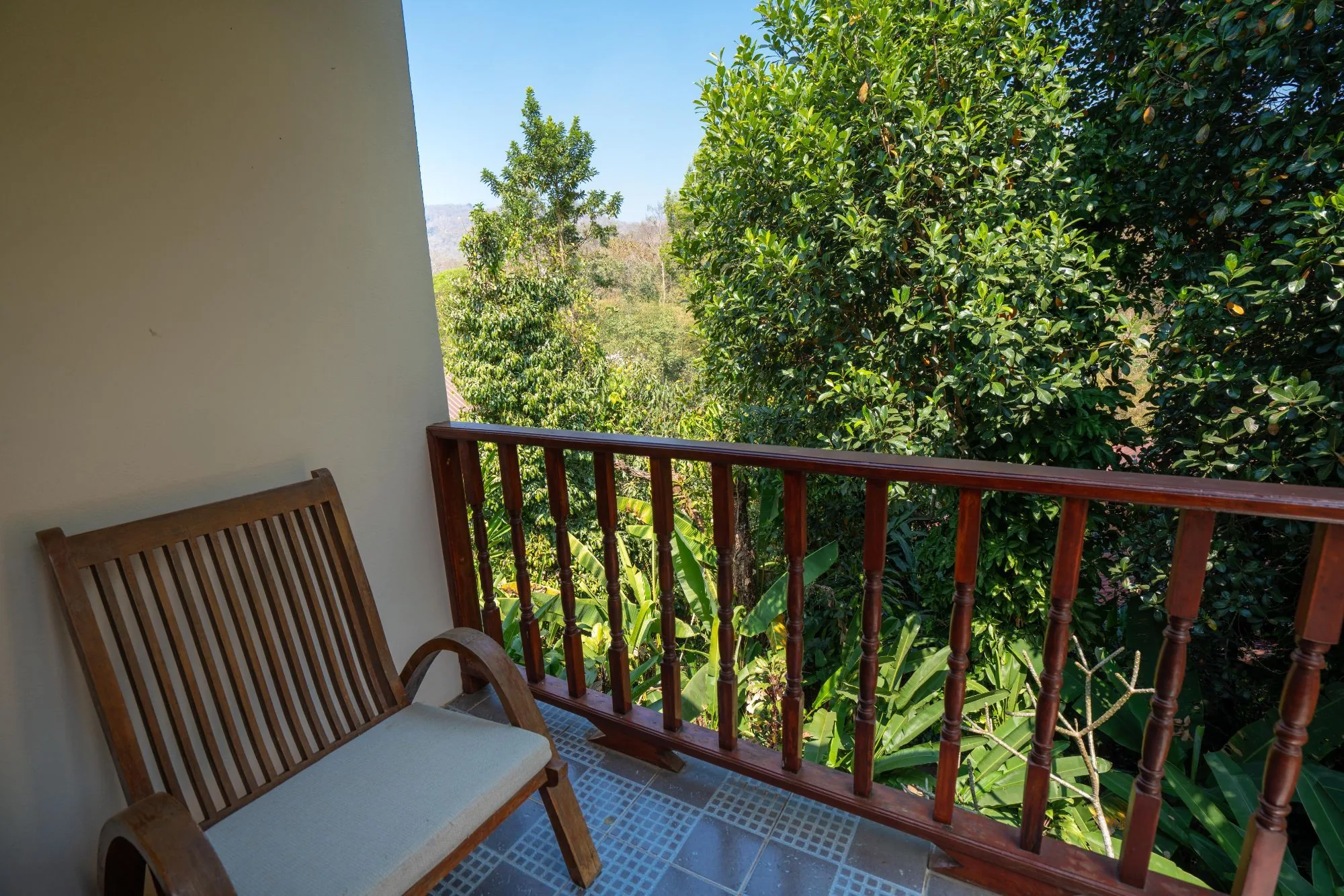 Private balcony with wooden chair overlooking the forest