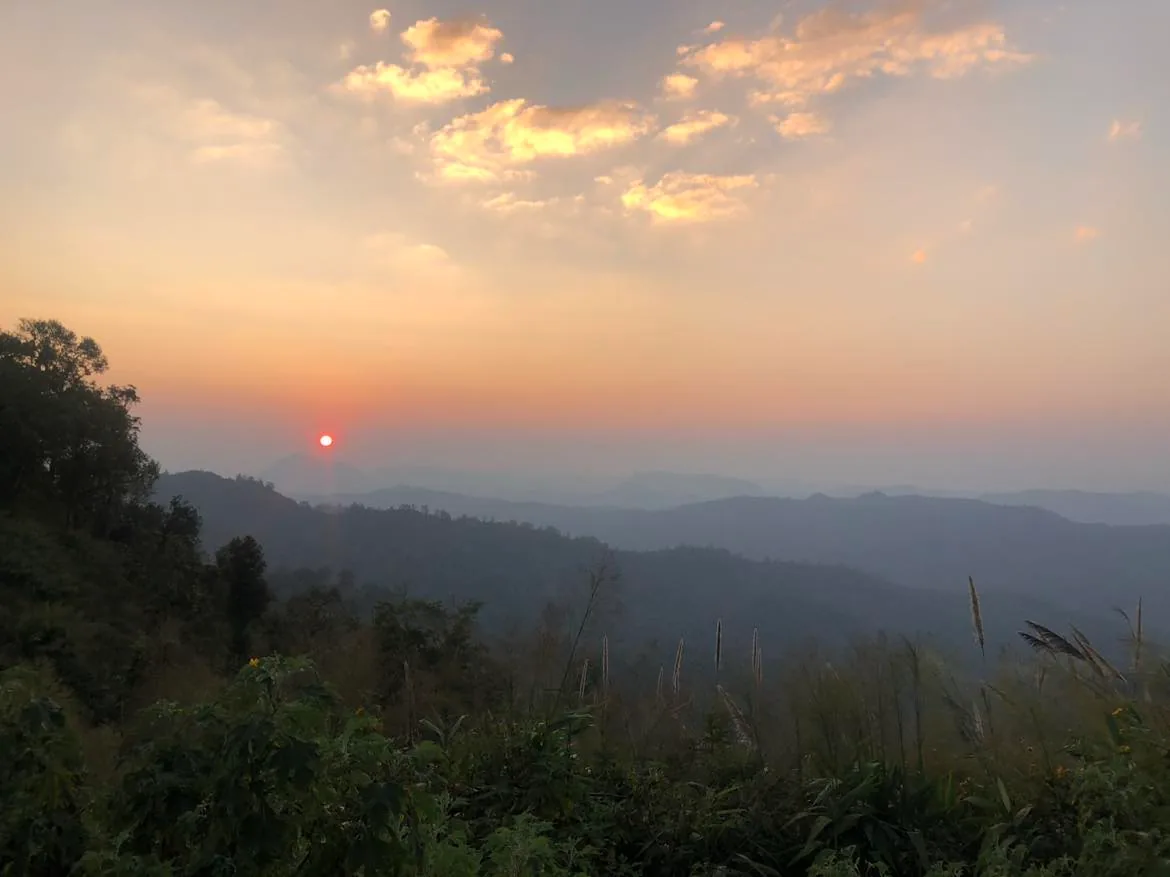 Red sun setting over the misty mountains of Pang Ma Pha